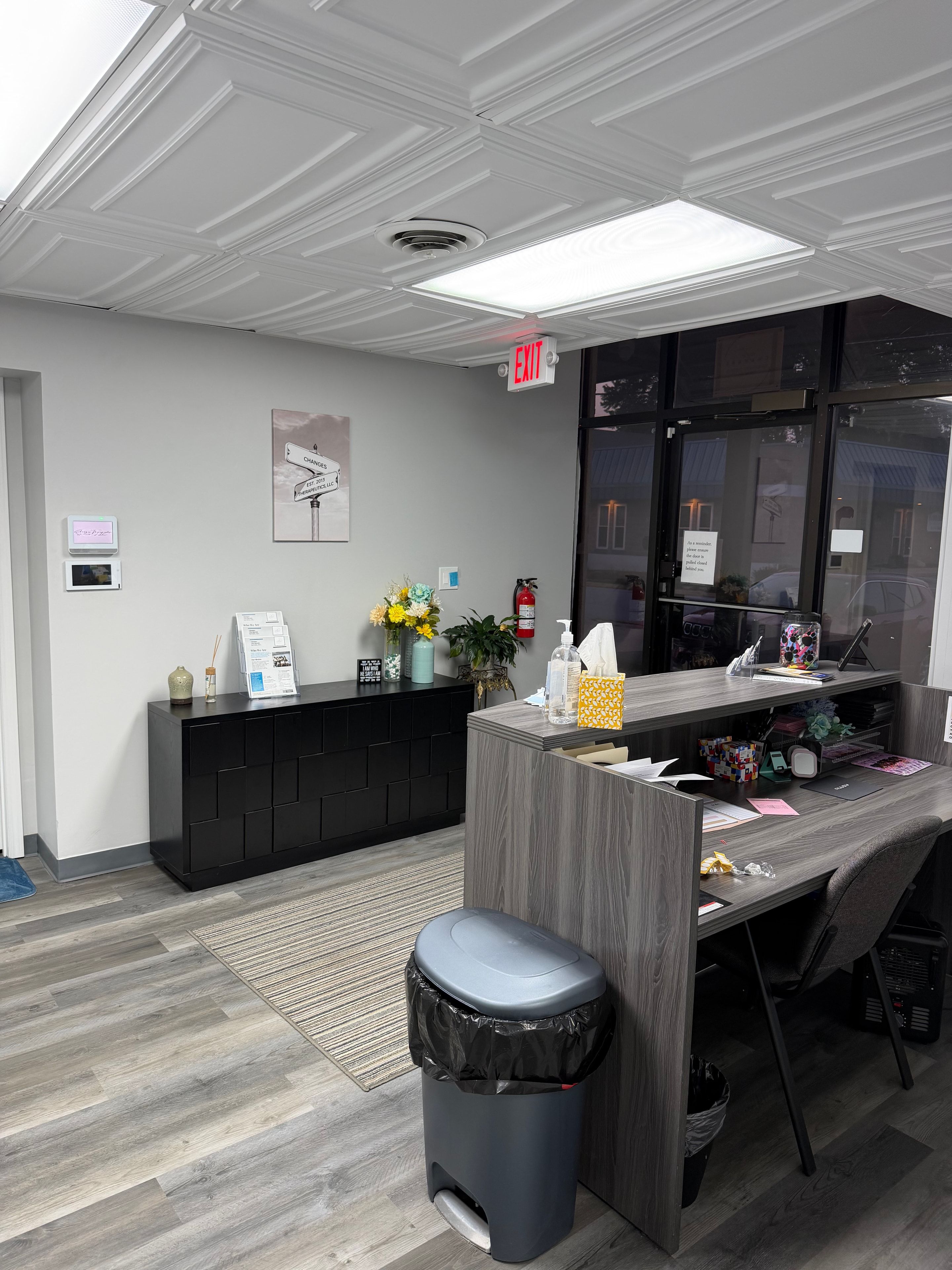 Changes Therapeutic Services reception area with front desk, Changes street sign art, and fresh flowers