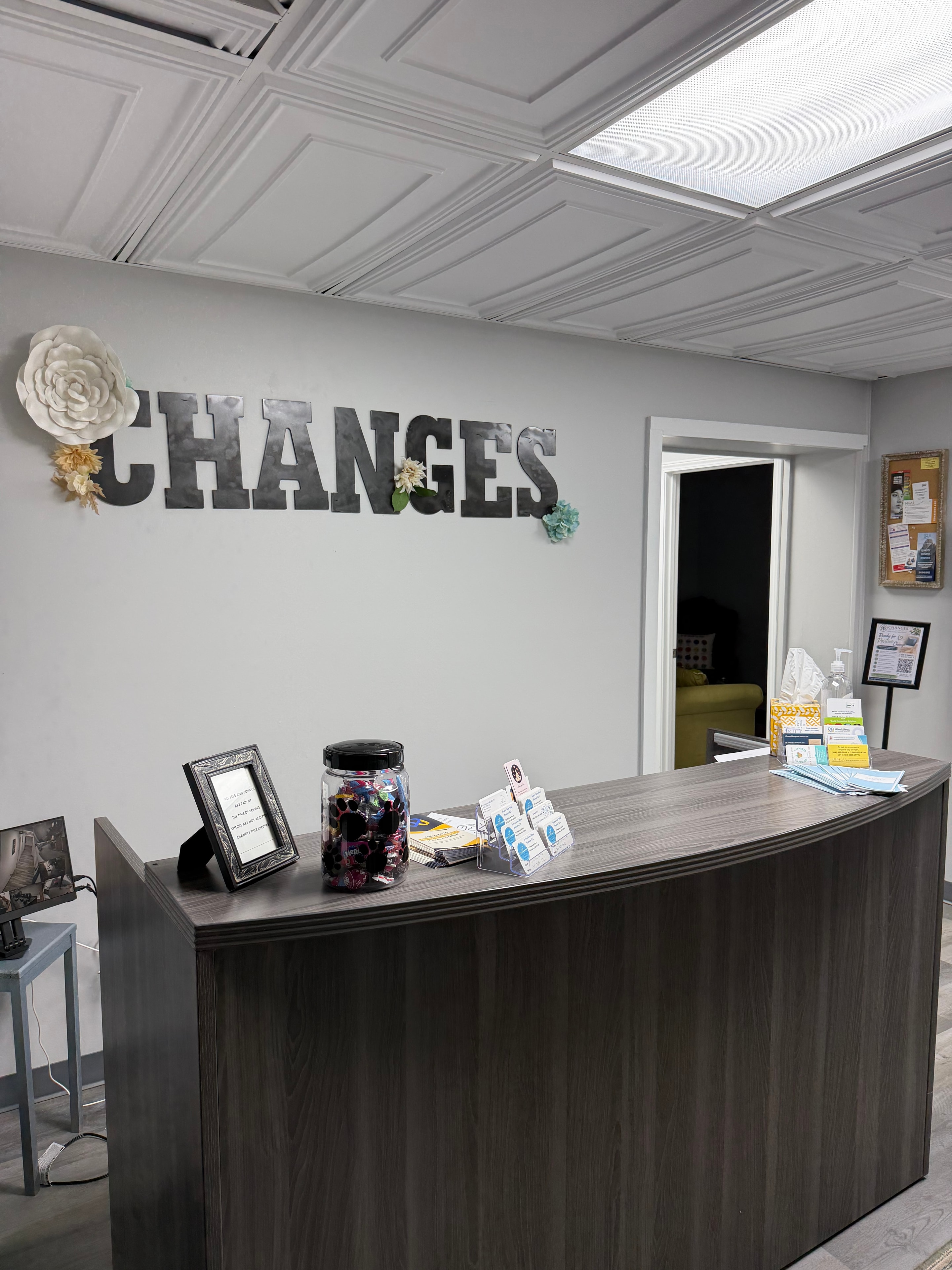 Changes Therapeutic Services reception desk with large CHANGES metal letter sign and paper flower wall decor