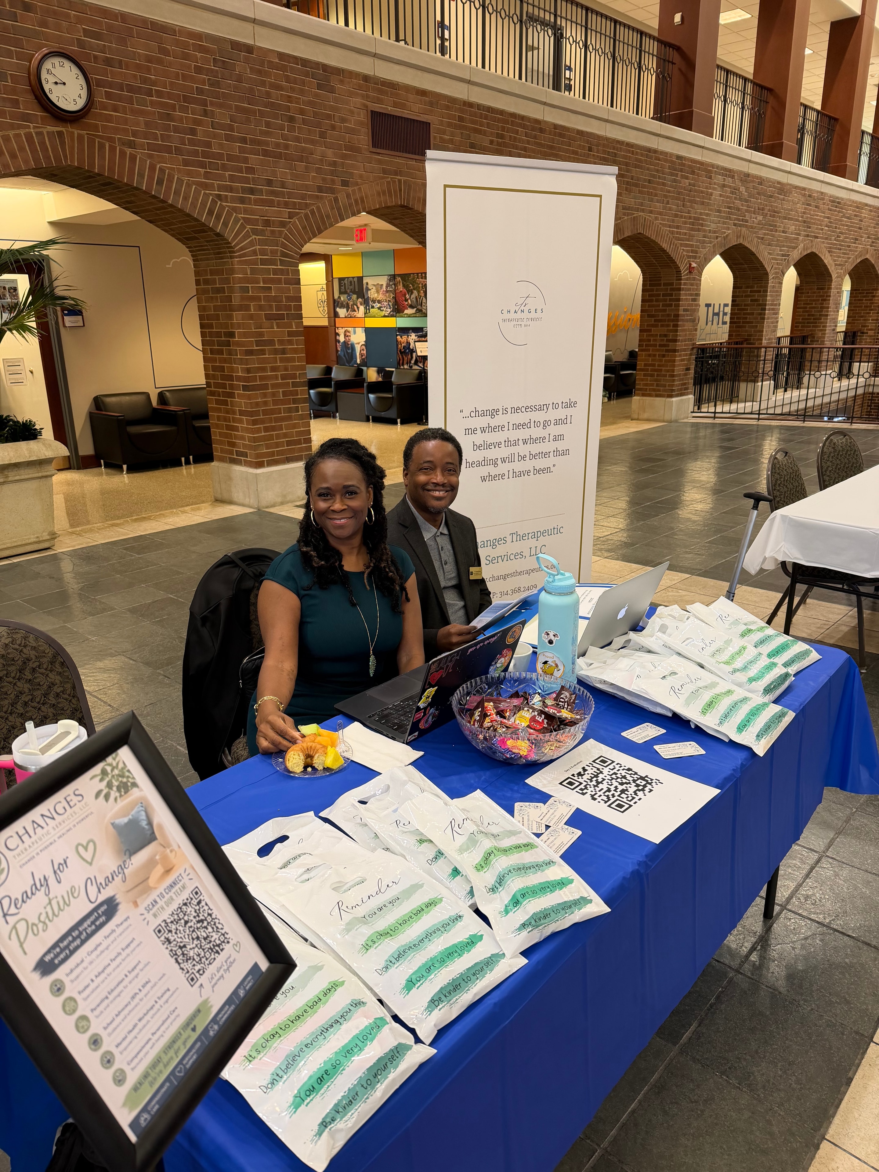 Changes Therapeutic Services team at a community event booth with promotional materials and affirmation bags