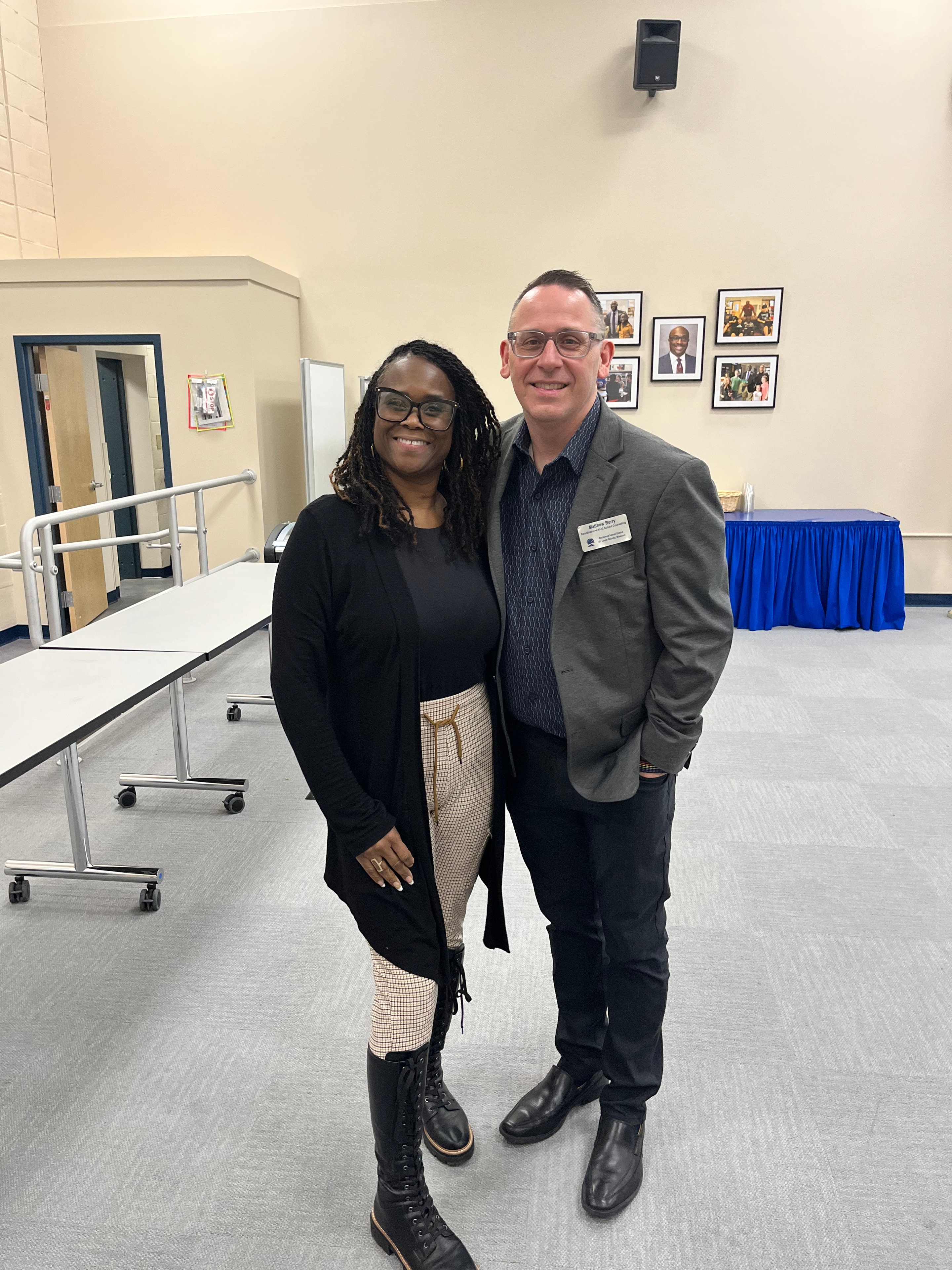 Two people posing together at an indoor community gathering