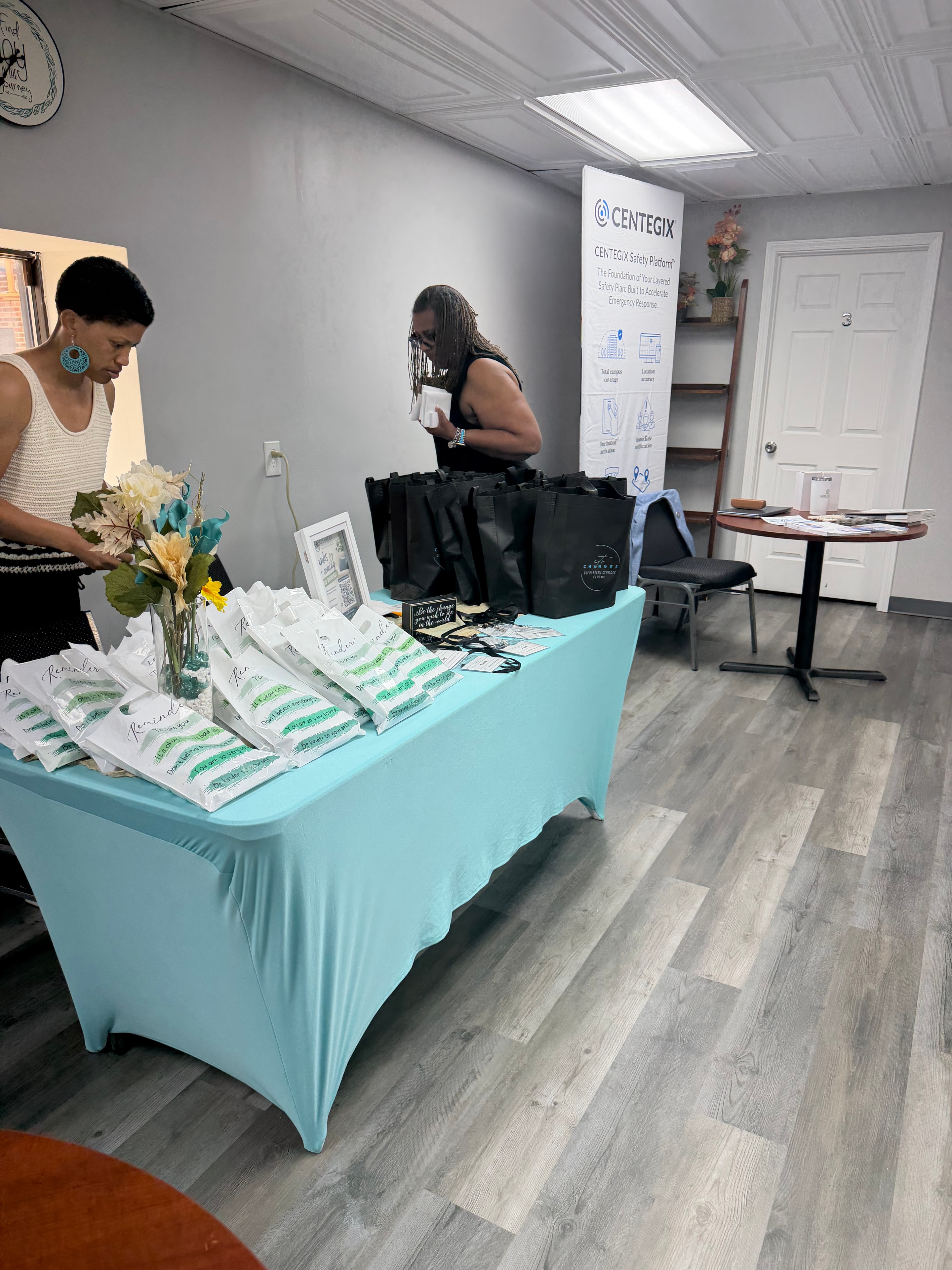 Changes Therapeutic Services team preparing resources at a turquoise-covered event table