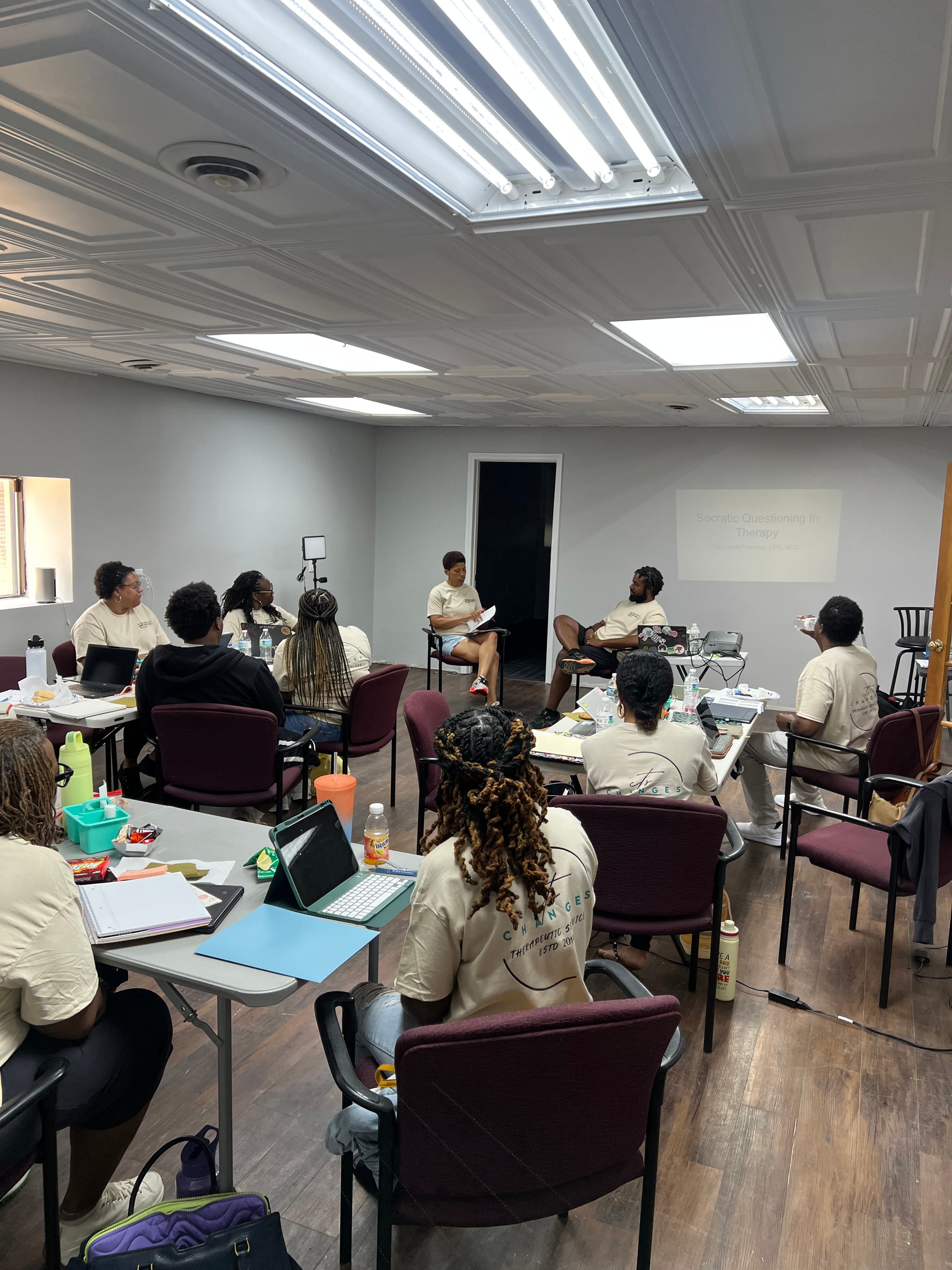 Participants seated at tables during a community workshop in a classroom