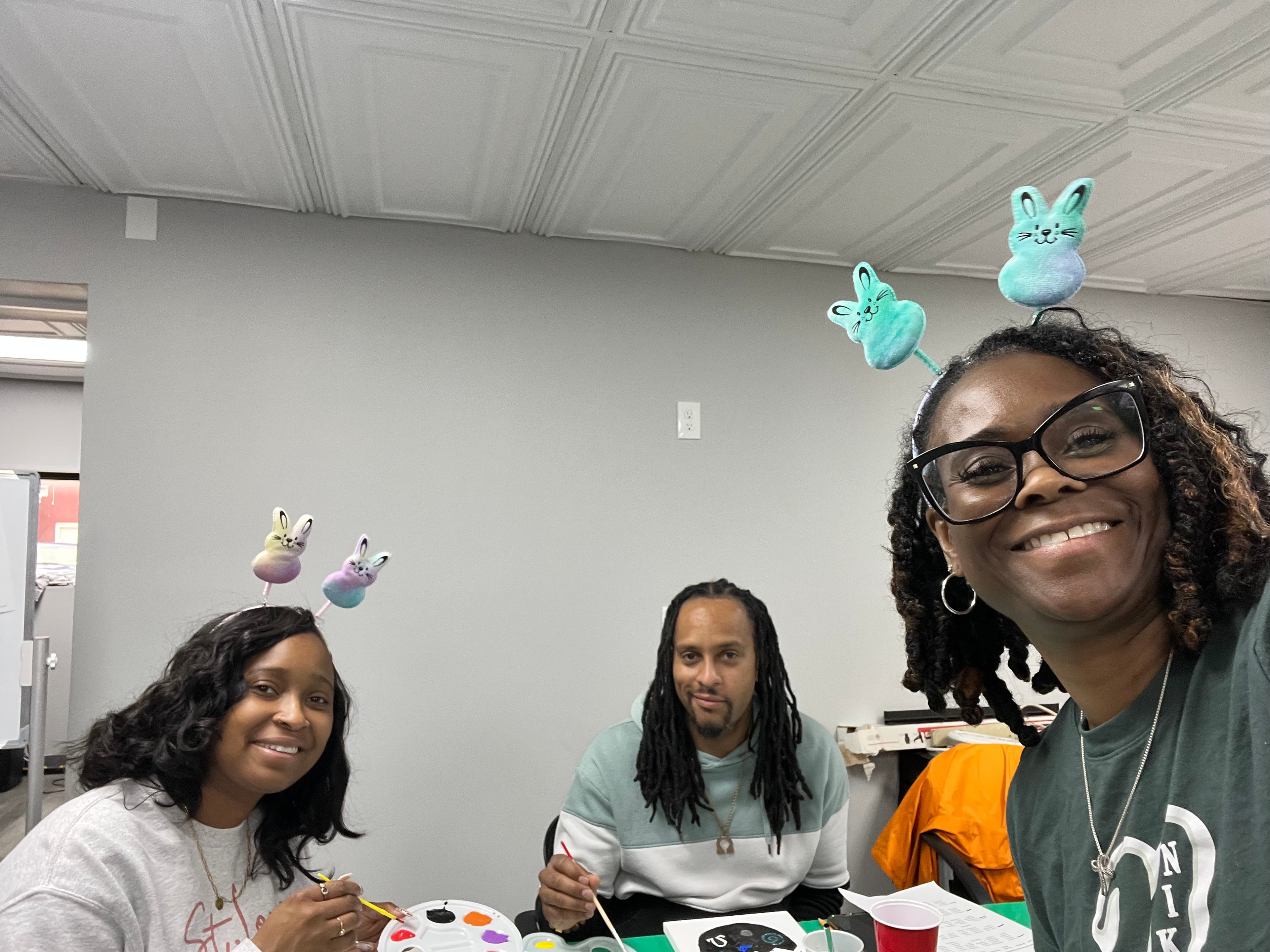 Three participants painting together during an Easter-themed activity