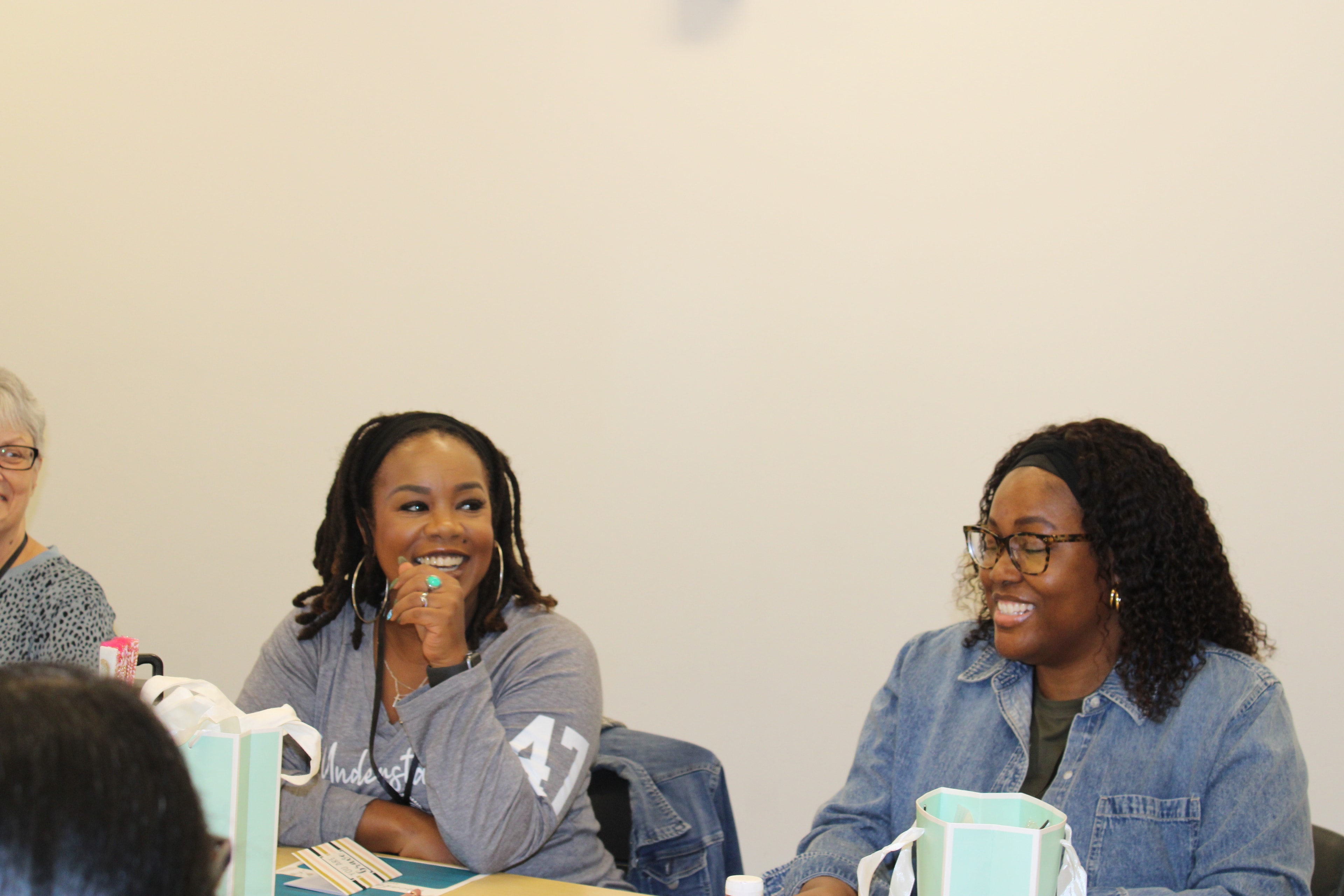 Event attendees smiling together at a table with gift bags and resources
