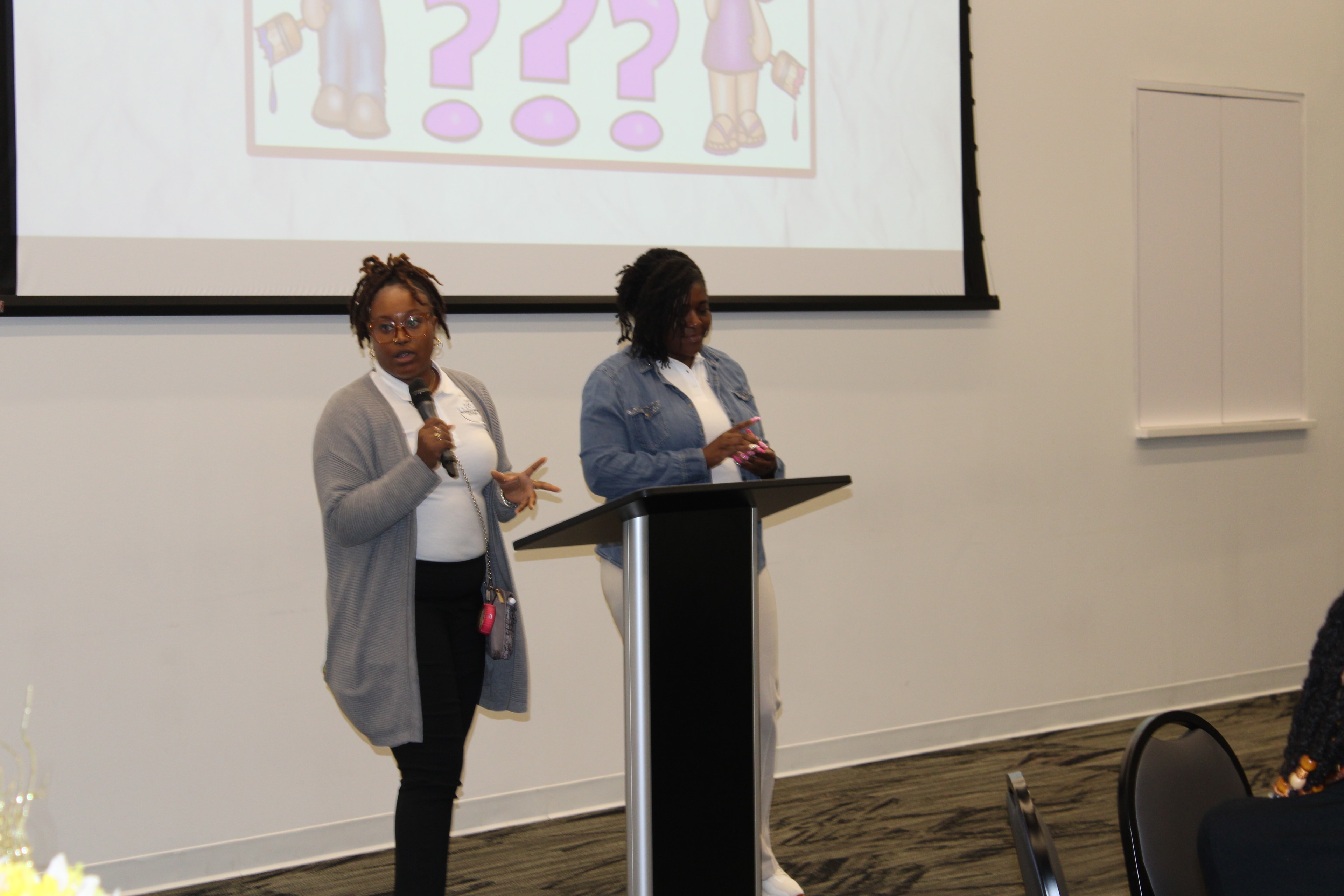 Two presenters speaking at a podium during a Changes Therapeutic Services event