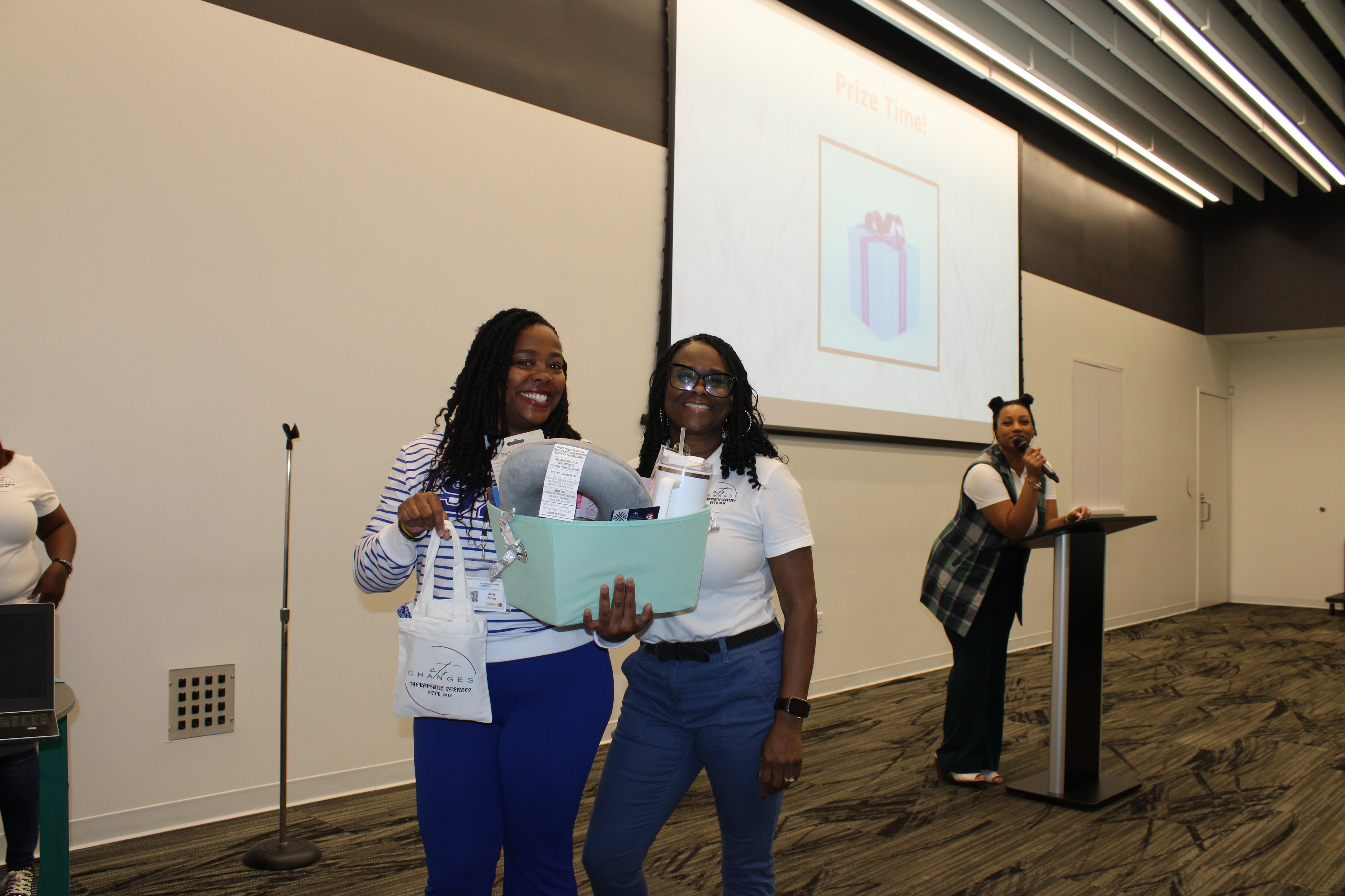 Changes Therapeutic Services team presenting a prize basket during a community event