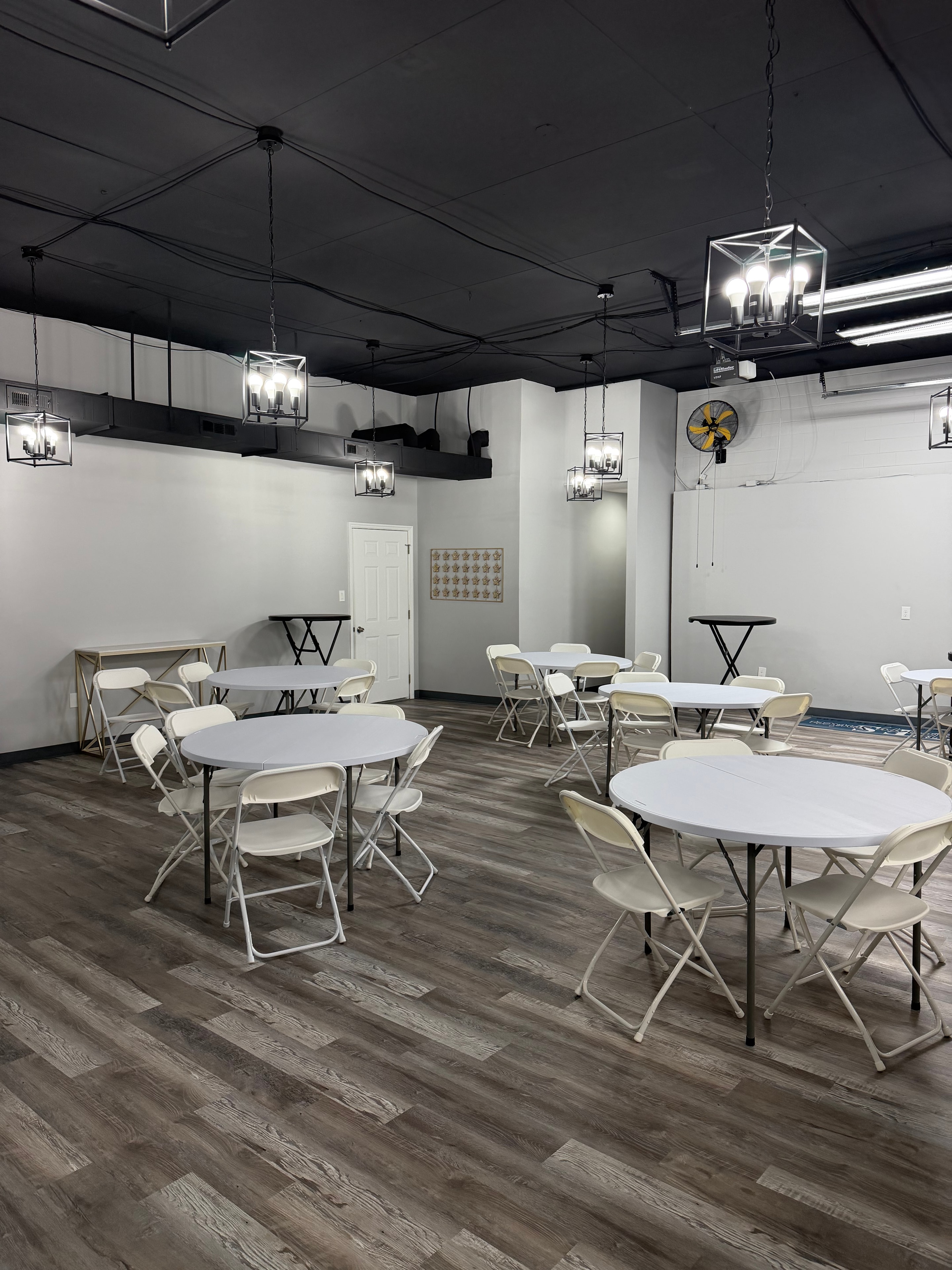 Event space interior with round tables and modern pendant lighting
